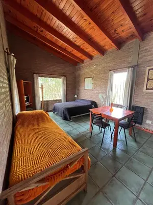 a bedroom with a bed and a table and a bed and a desk at Los Cardones de Mayu in San Antonio de Arredondo