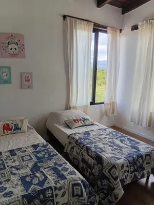 two beds in a room with a window at Lashara in Las Rabonas
