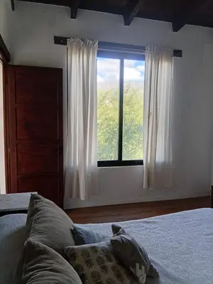 a bedroom with a bed and a large window at Lashara in Las Rabonas