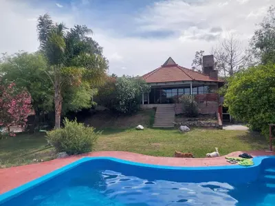 a large swimming pool in front of a house at Casa Numerosa Vista al lago con Pileta Villa Carlos Paz in La Porteña