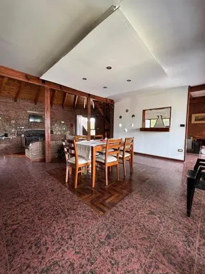 a dining room with a table and chairs at Casa Numerosa Vista al lago con Pileta Villa Carlos Paz in La Porteña