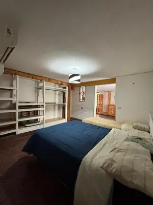 a bedroom with a large bed with a blue blanket at Casa Numerosa Vista al lago con Pileta Villa Carlos Paz in La Porteña