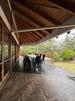 a patio with a table and chairs on it at Casa Numerosa Vista al lago con Pileta Villa Carlos Paz in La Porteña