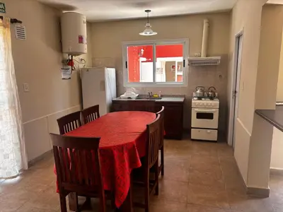 a kitchen with a red table with chairs and a refrigerator at Alma Apart in Los Molles