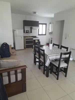 a dining room with a table and chairs and a kitchen at 9 de Julio 460 in Villa Carlos Paz