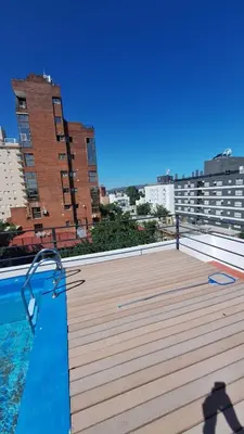 a large deck with a swimming pool on top of a building at 9 de Julio 460 in Villa Carlos Paz