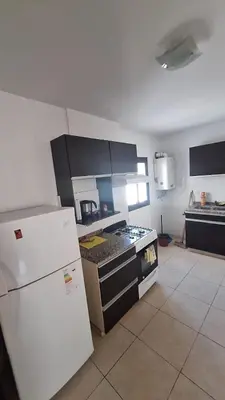 a kitchen with a stove and a white refrigerator at 9 de Julio 460 in Villa Carlos Paz