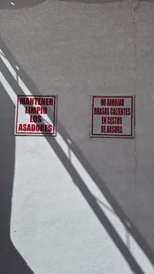 two signs on the wall of a building with a sign that reads no american at 9 de Julio 460 in Villa Carlos Paz