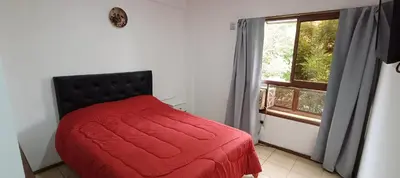 a bedroom with a red bed and a window at Complejo Aguaducho in Cordoba