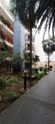 a building with a palm tree next to a sidewalk at Complejo Aguaducho in Cordoba