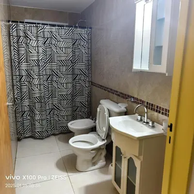 a bathroom with a toilet and a sink and a shower curtain at DUPLEX Stadium in Tanti
