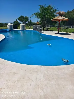 a large blue swimming pool with an umbrella at DUPLEX Stadium in Tanti