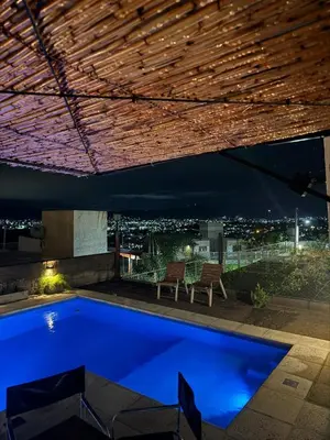 a swimming pool at night with a view of the city at Vistas del Valle II in Villa Carlos Paz