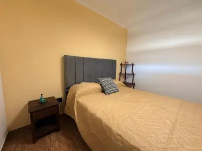 a bedroom with a bed and a side table at Vistas del Valle II in Villa Carlos Paz