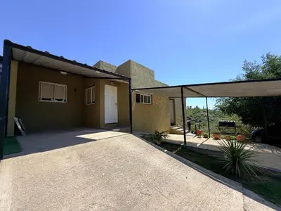 a house with a garage and a driveway at Vistas del Valle II in Villa Carlos Paz