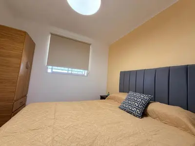 a bedroom with a bed with a blue headboard and a window at Vistas del Valle II in Villa Carlos Paz