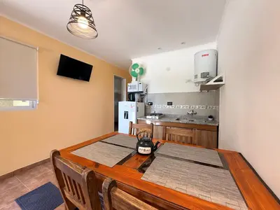 a kitchen with a wooden table and a kitchen with a refrigerator at Vistas del Valle II in Villa Carlos Paz