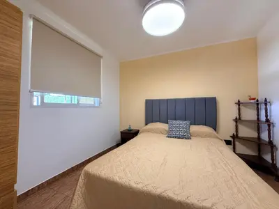 a bedroom with a bed with a blue pillow on it at Vistas del Valle II in Villa Carlos Paz