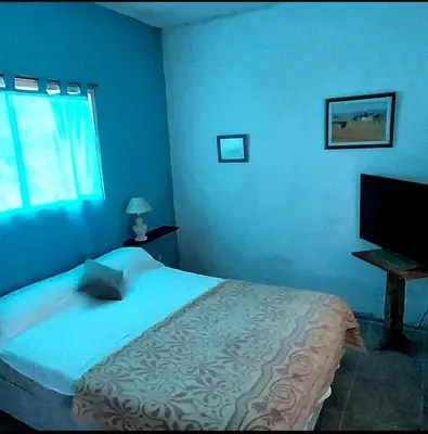 a blue bedroom with a bed and a television at La Serranita in Panaholma