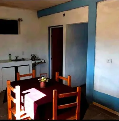 a dining room with a table and a kitchen at La Serranita in Panaholma