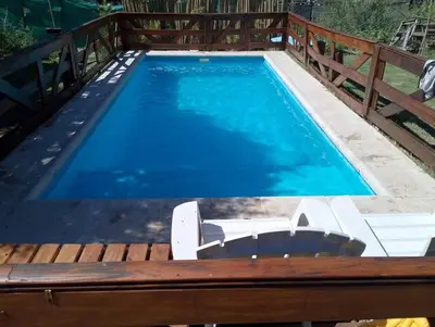 a swimming pool with a wooden fence around it at La Serranita in Panaholma
