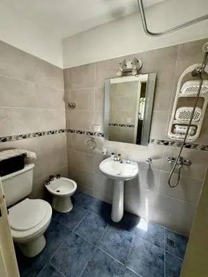 a bathroom with a toilet and a sink and a mirror at Apartment 2 blocks from downtown Located at the back of the house in Villa Carlos Paz