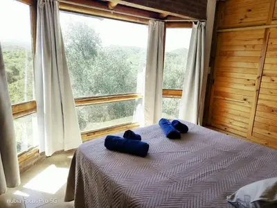two blue towels sitting on a bed in a room with a window at Mirador De Las Sierras in Villa Serranita