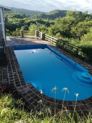 a large blue swimming pool on top of a house at Mirador De Las Sierras in Villa Serranita