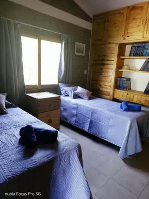 a bedroom with two beds and a window at Mirador De Las Sierras in Villa Serranita