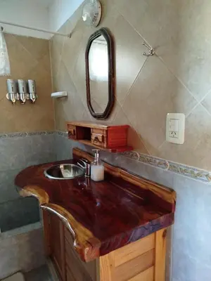 a bathroom with a wooden sink with a mirror at Mirador De Las Sierras in Villa Serranita