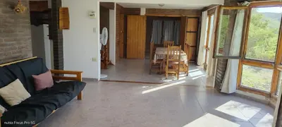 a living room with a couch and a table and chairs at Mirador De Las Sierras in Villa Serranita