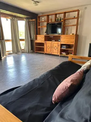 a living room with a bed and a tv at Mirador De Las Sierras in Villa Serranita