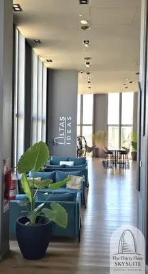 a lobby with blue couches and a potted plant at The Thirty Floor Sky Suite in Cordoba