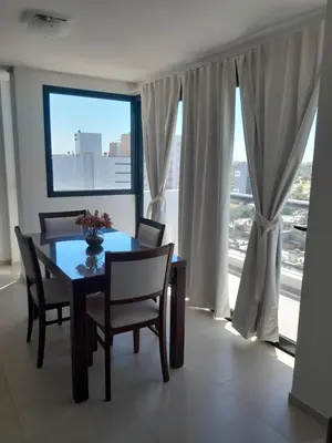 a dining room with a table and chairs and a window at Departamento luminoso a 4 cuadras del centro in Río Cuarto