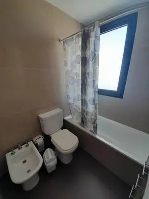 a bathroom with a toilet and a sink and a window at Departamento luminoso a 4 cuadras del centro in Río Cuarto