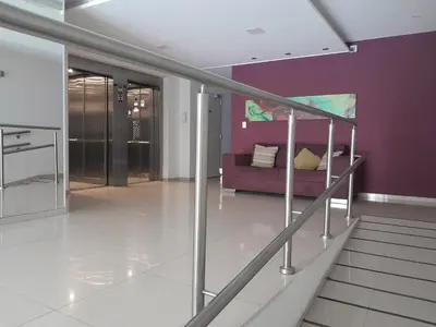a living room with a purple couch and stairs at Departamento luminoso a 4 cuadras del centro in Río Cuarto