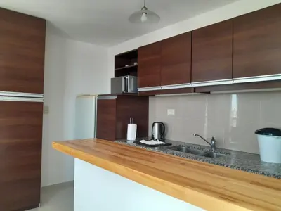 a kitchen with wooden cabinets and a sink at Departamento luminoso a 4 cuadras del centro in Río Cuarto