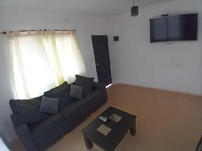 a living room with a couch and a table at Casa con pileta mina clavero in Mina Clavero