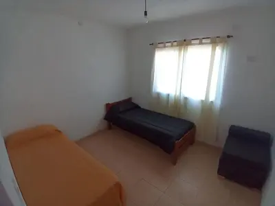 a small bedroom with a bed and a window at Casa con pileta mina clavero in Mina Clavero