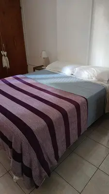 a bed with a striped blanket on it in a bedroom at Dpto 1 Ambiente Nva Cordoba, Capuchinos Buen Pastor in Cordoba