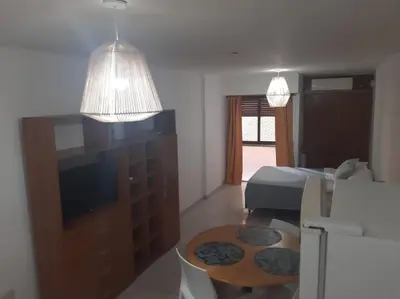 a living room with a bed and a table in a room at Dpto 1 Ambiente Nva Cordoba, Capuchinos Buen Pastor in Cordoba