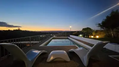 a swimming pool with two white chairs and a table at Casa- Villa Parque Siquiman in Villa Parque Siquiman