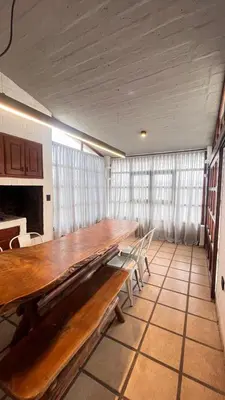 a long wooden table in a room with windows at Casa- Villa Parque Siquiman in Villa Parque Siquiman