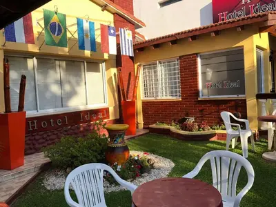 two white chairs and a table in a yard at Hotel Ideal vcp in Villa Carlos Paz