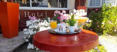 a table with two cups of juice and flowers on it at Hotel Ideal vcp in Villa Carlos Paz