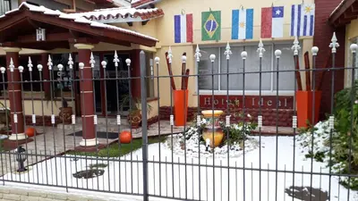 a school with a fence in front of a building at Hotel Ideal vcp in Villa Carlos Paz