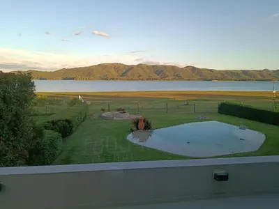 a view of a swimming pool in a yard with a lake at Casa lago dique los molinos in La Estancia