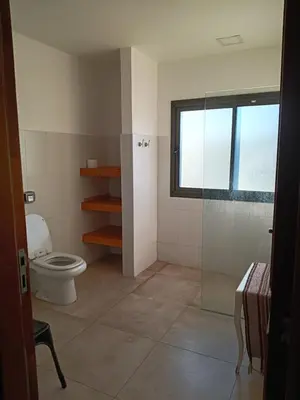 a bathroom with a toilet and a window at Casa lago dique los molinos in La Estancia