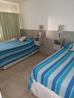 two beds in a hotel room with two beds sidx sidx sidx at Casa lago dique los molinos in La Estancia