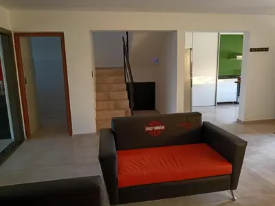 a living room with a couch and a staircase at Casa lago dique los molinos in La Estancia